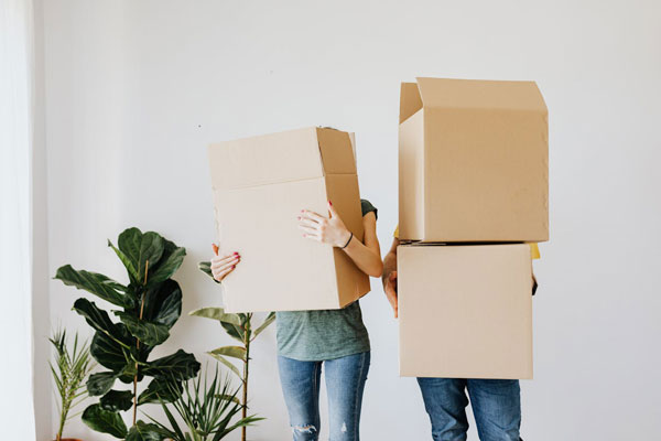 A couple carrying cardboard boxes