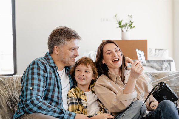 A family of three seated on the couch